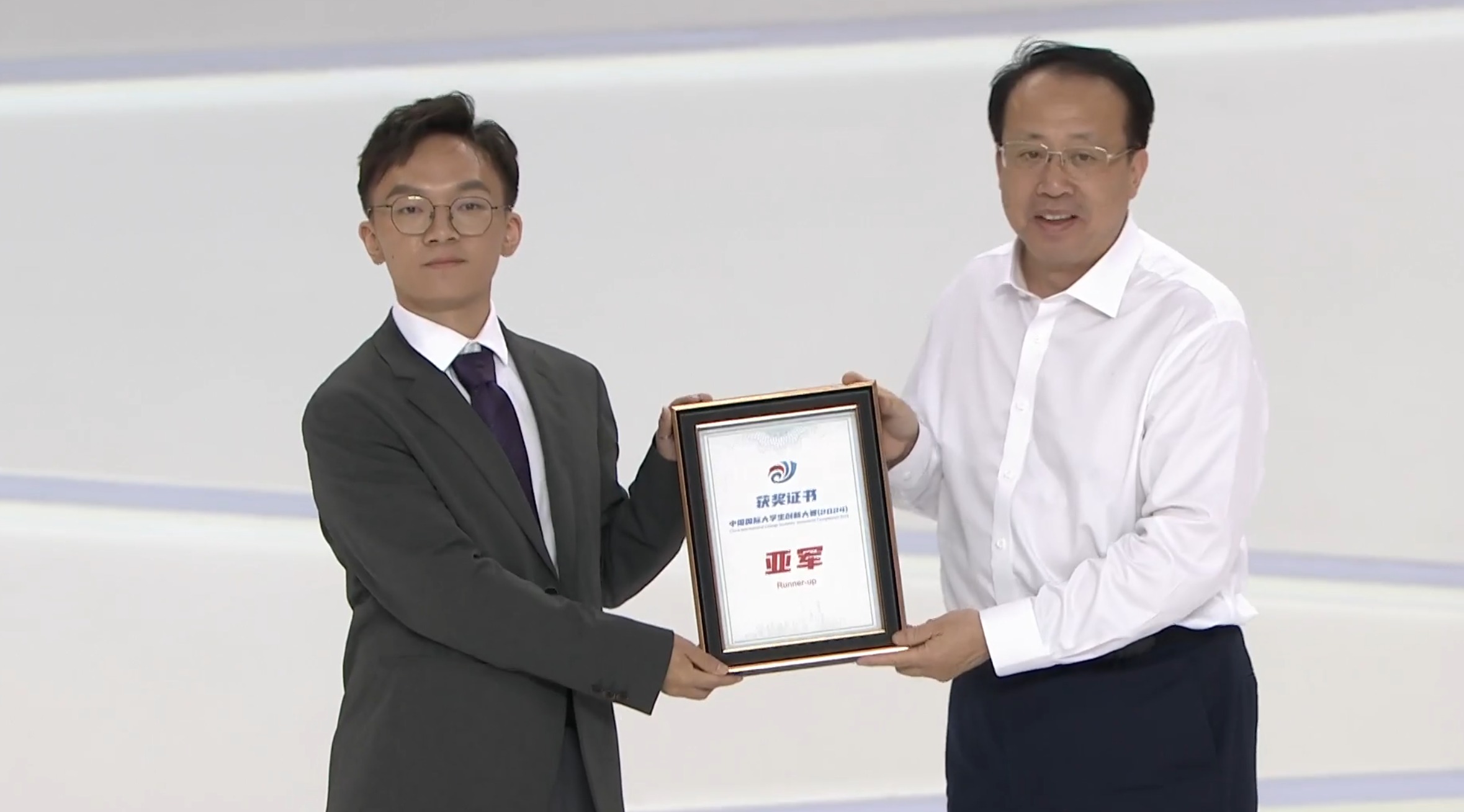 20241015-清华再次斩获中国国际大学生创新大赛总决赛亚军-大赛组委会-上海市市长龚正(右一)为“共绩算力”负责人付智(左一)颁奖.jpg